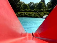 Rote Kinderrutsche mit Blick ins Wasser